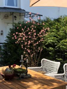 a table with two white wicker chairs and pink flowers at Willa Urocze in Muszyna