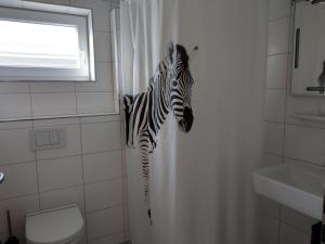 - une tête zébrée dans un rideau de douche dans la salle de bains dans l'établissement Grasshoppers, à Mössingen