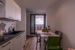uma cozinha com uma mesa e cadeiras verdes num quarto em La terrazza di Zoe - Castromediano ( Lecce) em Cavallino di Lecce