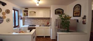 a kitchen with white cabinets and a refrigerator at Appartamento Serena in Abetone