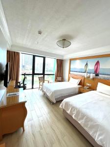 een hotelkamer met 2 bedden en een televisie bij ROYAL J HOTEL in Cebu City