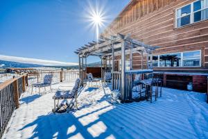 a deck with chairs and a slide in the snow at Sunrise Vista Villa in Angel Fire