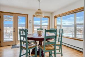 a dining room with a table and chairs and windows at Sunrise Vista Villa in Angel Fire