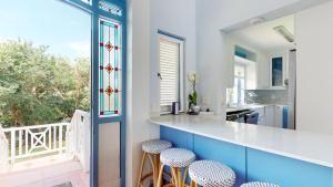 a kitchen with blue cabinets and a counter with stools at 36 Montego Bay Caribbean Estate by Top Destinations Rentals in Port Edward