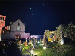 a building with a clock tower at night at Francesco House Family in Assisi