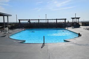 a large blue swimming pool with a pier in the background at Spark by Hilton Virginia Beach Oceanfront in Virginia Beach
