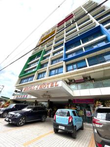 een hotel met auto's voor het hotel bij ROYAL J HOTEL in Cebu City