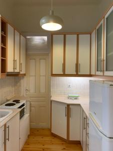 uma cozinha com armários brancos e um frigorífico branco em Anavros beach house em Volos