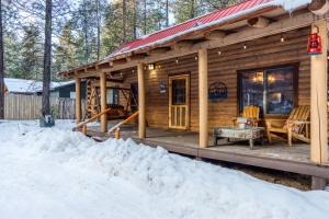 Cabaña de madera con porche en la nieve en Red Pines Log Cabin, en Sunriver