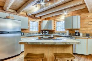 cocina con techos de madera, nevera y encimeras en Red Pines Log Cabin, en Sunriver