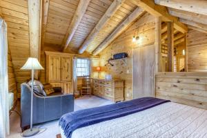 1 dormitorio en una cabaña de madera con cama y escritorio en Red Pines Log Cabin, en Sunriver