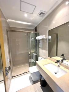 een badkamer met een douche, een wastafel en een toilet bij ROYAL J HOTEL in Cebu City