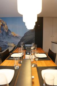 a long table with chairs and wine glasses on it at Casa Cervino 45 in Täsch