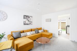 uma sala de estar com um sofá amarelo e uma mesa em Fortified Three Bedroom Home Bristol 