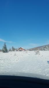 uma vista de um campo coberto de neve a partir de um carro em Vikendica Pašter em Šipovo