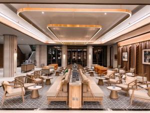 a hotel lobby with couches and tables and chairs at The Quarter Chaophraya by UHG in Bangkok