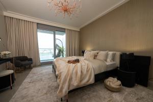 a bedroom with a large bed and a chandelier at Majestay - Luxury Living in Dubai