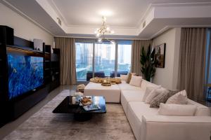 Majestay - Luxury Living في دبي: غرفة معيشة مع أريكة بيضاء وتلفزيون
