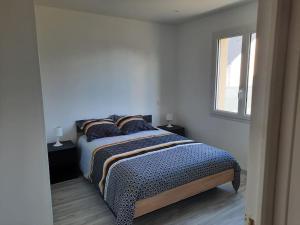 um quarto com uma cama com almofadas e uma janela em Maison neuve proche de la mer em Créances