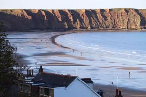 a view of a beach with people in the water at West Lodge, Filey. Sleeps 8, 7 mins walk to beach in Filey