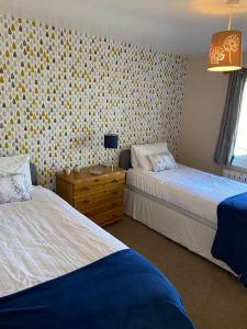 3 Bedroom Lodge with hot tub on lovely quiet holiday park in Cornwall tesisinde bir odada yatak veya yataklar