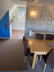 a dining room with a wooden table and chairs at 3 Bedroom Lodge with hot tub on lovely quiet holiday park in Cornwall in Gunnislake