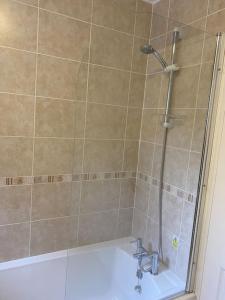 uma casa de banho com um chuveiro, uma banheira e um lavatório. em 3 Bedroom Lodge with hot tub on lovely quiet holiday park in Cornwall em Gunnislake