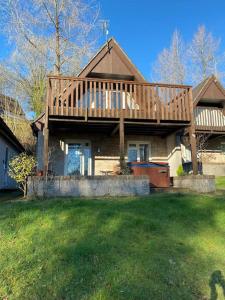 Gunnislakeにある3 Bedroom Lodge with hot tub on lovely quiet holiday park in Cornwallの庭の上にデッキ付きの大きな家