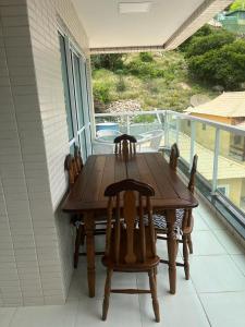 uma mesa de madeira e cadeiras num alpendre em Beach thoow férias em Arraial do Cabo