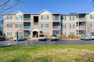a large apartment building with cars parked in a parking lot at Creekwood --- 100 Cascade Ln, #109 in Rehoboth Beach