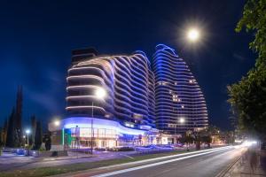 un edificio con luces azules por la noche en Limassol Del Mar en Limassol