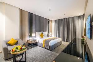 una camera d'albergo con letto e sedia di Erfad Hotel - Riyadh a Riyad
