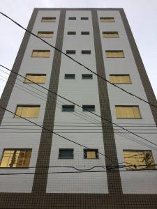a tall white building with lots of windows at Golden Apart Hotel in Aparecida