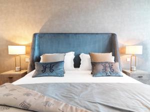 a large bed with a blue headboard and pillows at Limassol Del Mar in Limassol