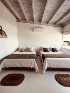 two beds in a room with rugs on the floor at Wala beach club in Cartagena de Indias