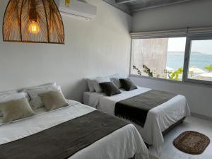 two beds in a room with a view of the ocean at Wala beach club in Cartagena de Indias