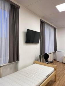 a bedroom with a bed and a flat screen tv at Central Hostel Jelgava in Jelgava