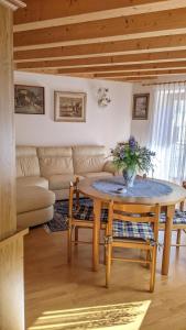 a living room with a table and a couch at Auronzo Vacanze di Marina e Valter - Corte 12 in Auronzo di Cadore
