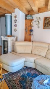 a living room with a couch and a stove at Auronzo Vacanze di Marina e Valter - Corte 12 in Auronzo di Cadore