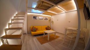 sala de estar con sofá amarillo y escalera en Trescene Room Locazione Breve Turistica, en Benevento