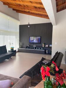 マイリンケにあるCasa de campo com Wi-Fi e lazer em Mairinque SPのソファとテレビのあるリビングルーム