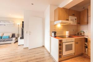 a kitchen and a living room with a couch at Hornhaus in Kitzbühel