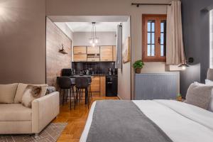 カラブリタにあるGM Luxury Suites Kalavrytaのベッドルーム1室(ベッド1台付)、リビングルーム、キッチンが備わります。