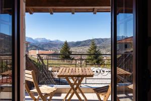 a table and chairs on a balcony with a view at GM Luxury Suites Kalavryta in Kalavrita