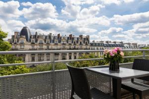 a table on a balcony with a view of a building at Citadines Bastille Marais Paris in Paris