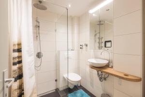 een badkamer met een toilet, een wastafel en een douche bij Hornhaus in Kitzbühel