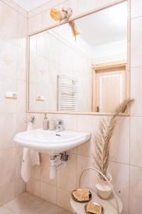 a white bathroom with a sink and a mirror at Willa Bór in Zakopane