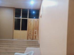 Habitación con nevera blanca y puertas de madera. en Tsabgyat Homestay, en Leh