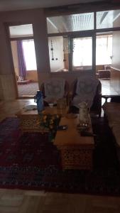 sala de estar con mesa y 2 sillas en Tsabgyat Homestay, en Leh