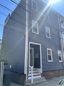 a blue house with a front door and stairs at Lovely Two Bedroom Condo in South Boston in Boston
